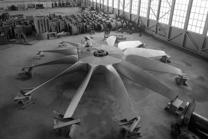 Large wind-tunnel fan blades laid out for assembly on a hangar floor (1943)