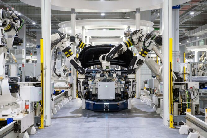 Automated robotic arms assembling a car in a high-tech electronics manufacturing facility.