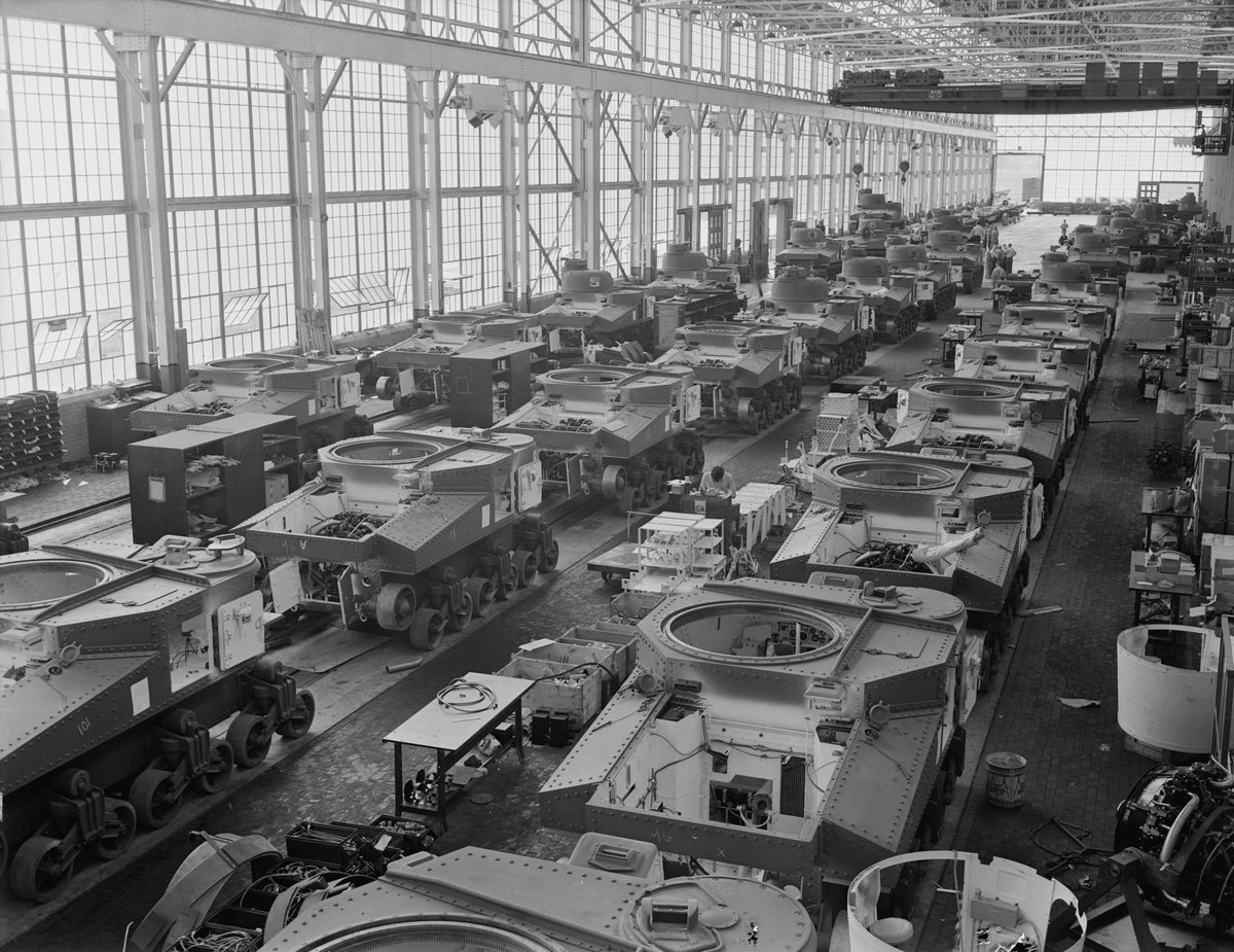 Rows of partially completed M3 tanks on three assembly lines inside the Chrysler tank arsenal, with overhead cranes.