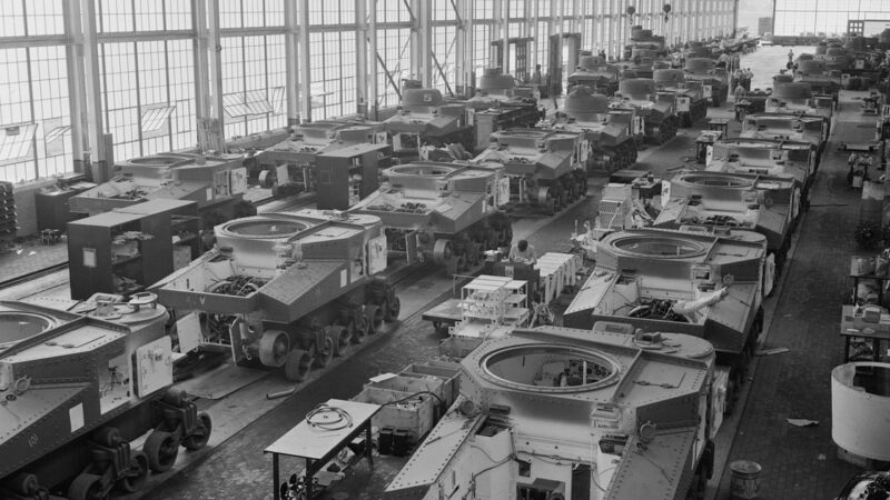 Rows of partially completed M3 tanks on three assembly lines inside the Chrysler tank arsenal, with overhead cranes.